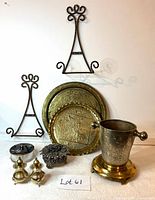 Full lot showing metal hanging plate holders, brass trays, glass jar with decorated lid, silver-plated trinket box, and silver-plated salt and pepper shakers.