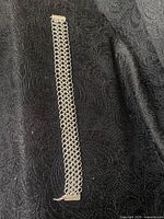 Full view of sterling silver 925 chainmail bracelet on black textured fabric