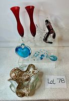 Overview of all Murano glass items with red vases, glass bird, blue heart perfume bottle, necklace, and large gold speck vase.