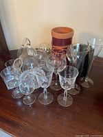 Front angled view of all glassware and ceramic vase arranged on wooden surface