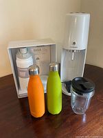 Photo showing two insulated stainless steel bottles, Sodastream machine, Ninja Nutri blending cup, and boxed Hydrapeak Oasis bottle