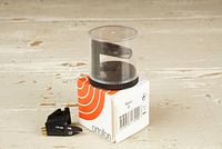 Ortofon OMB 30 cartridge with protective clear plastic stylus cover atop the white and orange Ortofon box, with OMB 14 stylus placed on table surface