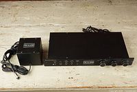 Full view of preamplifier and external power supply side by side on white surface