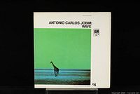 Front cover of the Antonio Carlos Jobim Wave vinyl record showing artwork with a giraffe by the ocean and album title.