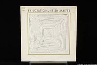 Front cover of the Keith Jarrett Expectations LP showing abstract embossed wavy lines artwork on white background.