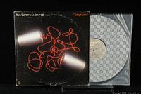 Vinyl LP record and album cover showing front cover artwork with telephone cans and red string design, record in plastic sleeve