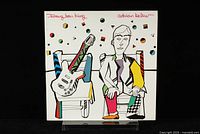Front cover of the Adrian Belew Twang Bar King vinyl LP featuring abstract artwork with colorful guitars and a figure.