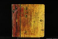 Front closed view of gatefold vinyl record cover featuring a wooden desk graphic with scribbles and a trophy