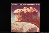 Front cover of Blue Öyster Cult Cultösaurus Erectus album showing dinosaur head artwork with purple and beige tones