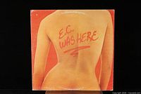 Front cover of Eric Clapton vinyl record 'E.C. Was Here' showing a bare back with red text written on skin.