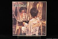 Front cover of Linda Ronstadt's Simple Dreams album showing artist reflected in a mirror, sitting on a white chair wearing a robe.