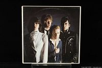 Front cover featuring a photo of the Pretenders band members dressed in classic new wave rock style clothing.
