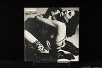Front cover of the 'Love At First Sting' Vinyl LP by Scorpions, showing a black and white image of a man and woman in a close embrace, with the album title and band name.