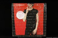 Front cover of sealed Loverboy vinyl LP record showing large red 'V' with woman wearing black and holding cigarette, shrink-wrap intact.