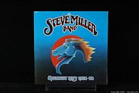 Front cover of the Steve Miller Band Greatest Hits 1974-1978 LP showing cover art with blue background and horse head graphic.