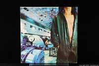 Front cover of UFO Lights Out vinyl album showing industrial setting and man with open shirt.