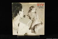 Front cover of UFO vinyl LP 'No Heavy Petting', showing photo of woman with monkey, neutral background.