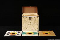 Record case open with three singles in front