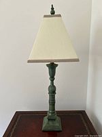 Full view of the vintage green table lamp with tapered shade on wooden surface