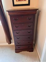 Front view of Broyhill 6 drawer dresser showing dark brown finish, metal handles, keyhole details, and decorative molding on top and base.