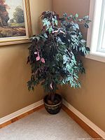 Full view of the faux tree in corner with decorative planter and wall art in the background.