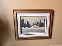 Framed watercolour painting showing full view of snowy winter scene with house and trees