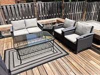 Overall view of patio set arranged on deck showing loveseat, two chairs, side table, and coffee table
