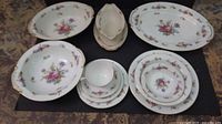 Photo showing full set of Aladdin Fine China with floral patterns and gold trim on various plates, bowls, and serving dishes