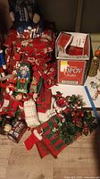 Overview of Christmas decorations including cushions, greenery, Elf figure, candles, and decorative items arranged on the floor next to a box