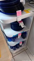 Photo showing white painted corner shelves with blue plates and cups on shelves (not included in lot).