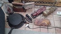 Overview of the antique cast-iron and brass fireplace tools including duck doorstop, waffle maker, brass poker, and other decor items