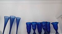 Three tall cobalt blue glass trumpet-shaped vases with flared tops