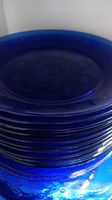 Stack of deep blue glass plates showing thickness and general condition.