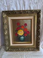 Framed floral still life oil painting in an ornate gold frame with a cream linen inner border.