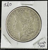 Obverse side of the 1880 US Morgan silver dollar showing Lady Liberty and year 1880 with 'E PLURIBUS UNUM' inscription.