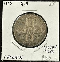Reverse side of 1913 Great Britain King George V silver florin coin in cardboard holder, showing four crowned shields arranged in cross and inscription details including date 1913.