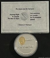 Overall view of the coin in protective case with certificate showing the Anson and Harvard aviation theme and bilingual text.