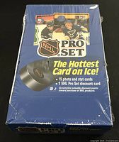 Front view of factory sealed blue box labeled NHL ProSet 1990 Series 1 with hockey players and a hockey puck image.