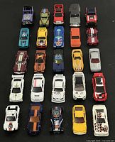 Top view showing all 25 die cast cars and trucks arranged in rows on black background