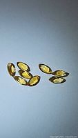 Seven natural golden citrine marquis cut gemstones displayed on white background, showing top and angled views.