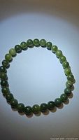 Close-up photo of a natural green jade bead stretchy bracelet.