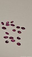 Multiple marquis cut untreated rubies displayed on a neutral background, showing color and cut.