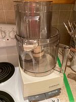 Full view of the assembled Cuisinart Professional 14 food processor on a kitchen countertop beside a stove.