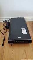 Top view of Epson V600 Photo scanner and power adapter with cord visible