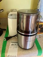 Stainless steel Cuisinart spice and nut grinder with black base and transparent measurement lid.