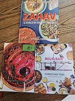 Photo showing covers of 'Zahav', 'Tartine All Day', and 'Milk Bar Life' cookbooks on a wooden surface.