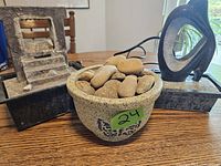Photo showing three different indoor decorative fountains on a wooden table with natural light, including stone staircase fountain, abstract stone sculpture fountain, and bowl filled with stones fountain.