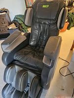 Front-left three-quarter view of black and gray Osaki massage chair showing seat, armrests and footrest.