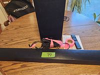 Samsung black soundbar, power cables, and subwoofer on a wooden table.