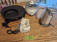 Photo of all four small kitchen appliances on wood table: Rival crock pot, Hamilton Beach coffee grinder, West Bend can opener, and white hand mixer.
